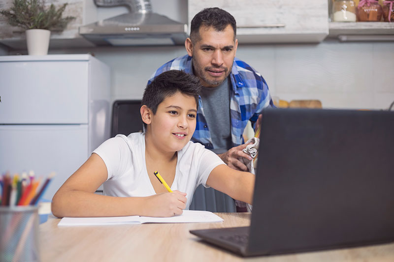 Father and son working together on a laptop at home
